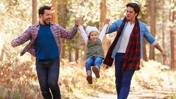 Homosexuelles Paar mit Tochter bei Waldspaziergang